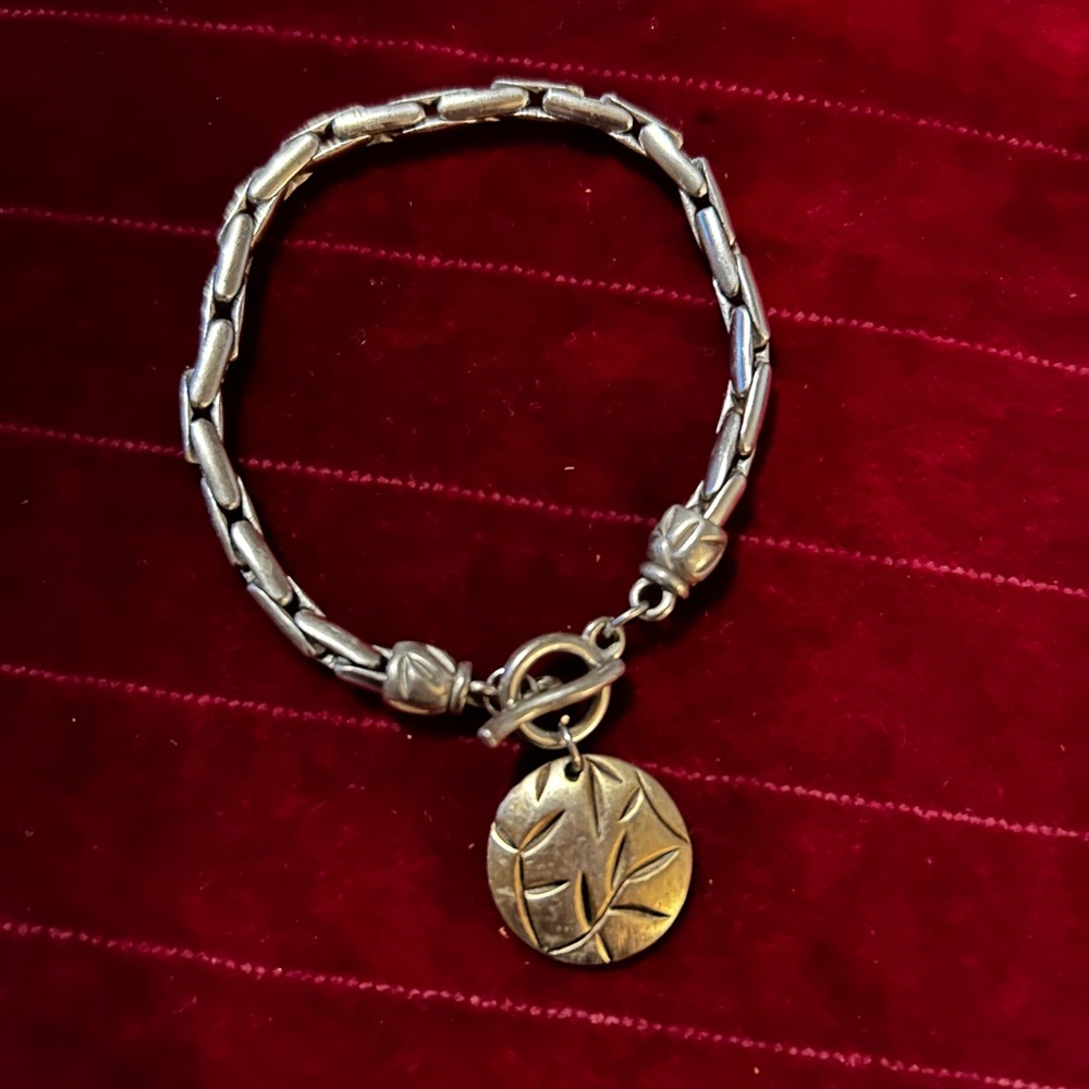 Elegant Silvertone Bracelet with brasstone Charm.